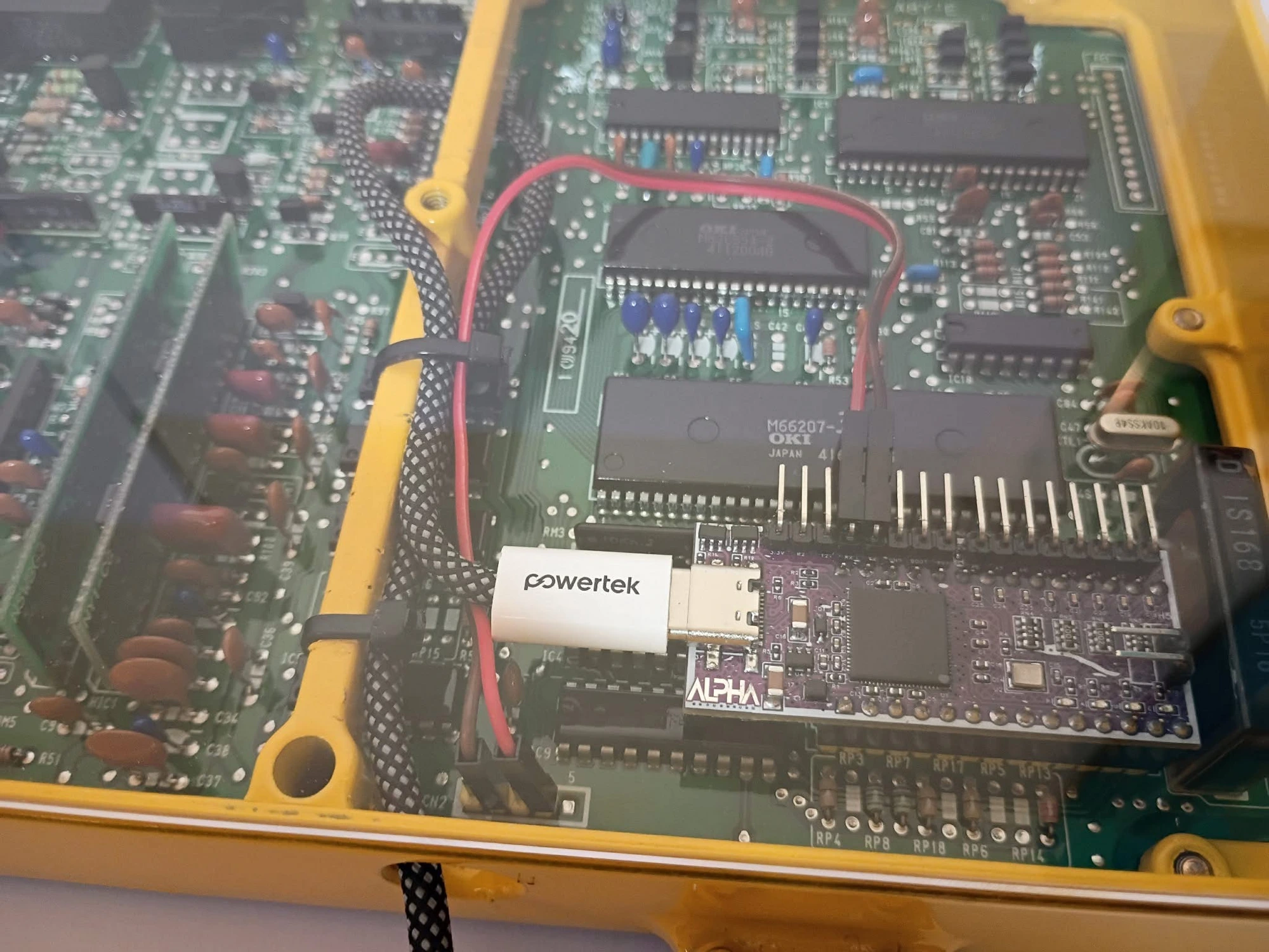 Close-up of an ALPHA emulator board socketed onto a Honda ECU, USB adapter connected